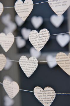 paper hearts are strung on a string with words in the shape of heart's