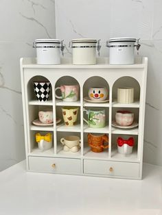 a white shelf with cups and saucers on it