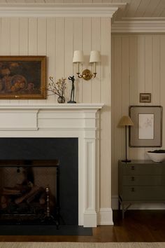 a living room with a fire place next to a painting on the wall above it