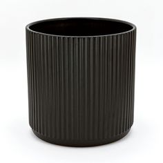 a black vase sitting on top of a white table