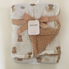 a blanket with a teddy bear design on it and a tag attached to the back