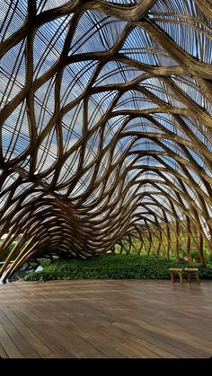 a wooden floor with an artistic design on the ceiling and benches in front of it