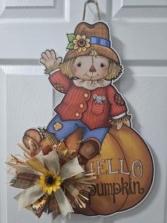 a door hanger with a scarecrow on it's front and the words hello pumpkin