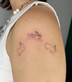 a woman's arm with two rabbits on it and one bunny in the middle