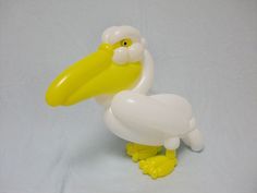 a yellow and white balloon shaped like a pelican with a large beak on it's feet