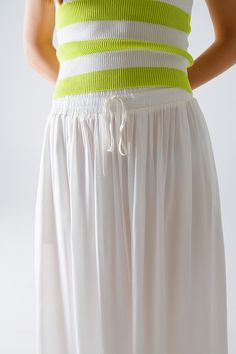 Introducing our stunning Maxi Skirt in White Fluid Fabric with Elastic Waist, a versatile and chic addition to your wardrobe that exudes effortless bohemian style. Crafted from lightweight woven fabric made of 100% viscose, this skirt offers both comfort and elegance.  The full-length design and relaxed fit create a flowing silhouette that's perfect for any occasion, whether you're strolling along the beach or attending a summer soirée. The elastic waistband ensures a comfortable and customizable fit, while side pockets add a practical touch.  Pair this skirt with a simple tank top for a casual daytime look, or dress it up with a blouse and statement jewelry for a more polished ensemble. However you style it, this maxi skirt is sure to make a statement wherever you go.  Please note that th