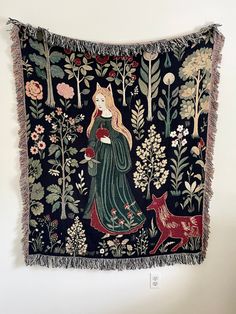 a tapestry hanging on the wall with an image of a woman in a green dress