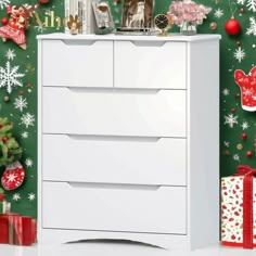 a white dresser sitting next to a christmas tree with presents on it's side