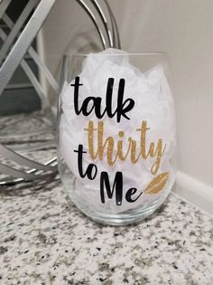 a wine glass with the words talk thirty to me written in gold foil on it