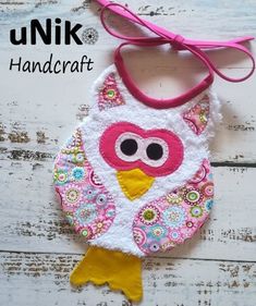 an owl ornament hanging on a white wooden background with the words unik handcraft