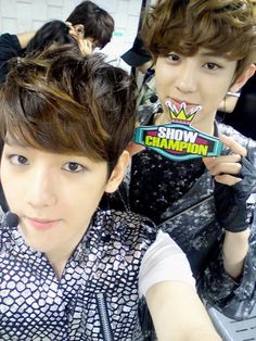 two young men are posing for the camera with one holding up a sticker that says show champion