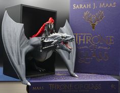 a game of thrones dragon figurine sitting on top of a purple box