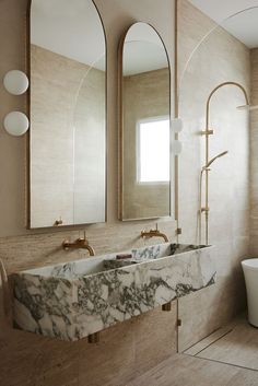 a bathroom with marble counter tops and two mirrors on the wall, along with a tub