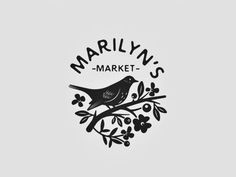 a bird sitting on top of a tree branch with the words marilyn's market