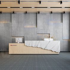 an office lobby with a marble counter and white vase on the front desk, surrounded by concrete wall panels