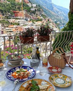 a table topped with plates and food on top of a white tablecloth covered patio