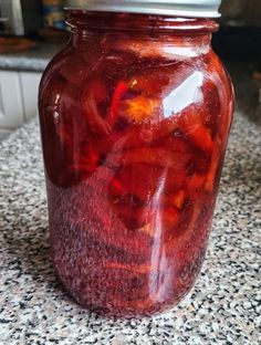 a jar filled with red liquid sitting on top of a counter