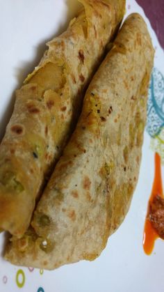 two burritos sitting on top of a white plate