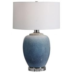 a blue table lamp with a white shade on the base and a silver frame around it