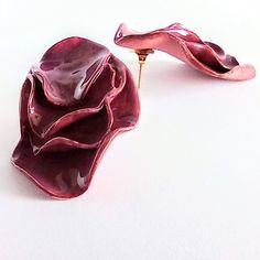 a flower shaped brooch sitting on top of a white table