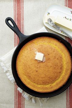 a pancake with butter in it sitting on a table next to a knife and fork