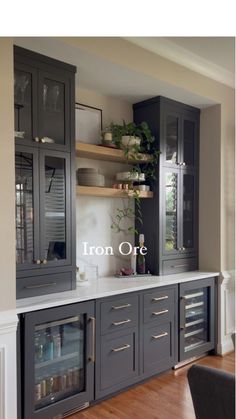 a kitchen with gray cabinets and white counter tops