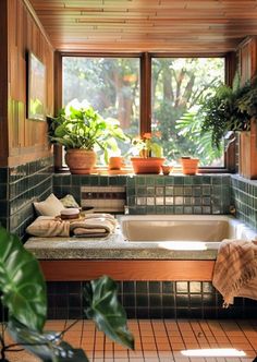 a bath tub sitting next to a window filled with potted plants and greenery