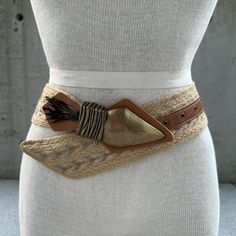 90s jute belt, chunky arrowhead buckle with feathers, vintage summer accessories, tribal fashion statement belt, boho hippie, tribal glam  Transport yourself to the free-spirited vibes of the 90s with our Vintage Jute Belt, a distinctive accessory that effortlessly captures the essence of summer style. This tribal fashion statement belt is a fusion of boho hippie allure and tribal glam, a wearable masterpiece that invites you to embrace the artistry of vintage summer accessories. Crafted from jute, the wide band showcases intricate embroidery in neutral tones, creating a harmonious canvas that tells a story of ethnic elegance. The chunky arrowhead buckle takes center stage, a bold adornment that adds an element of tribal mystique to the belt. Adorned with feathers, it becomes a symbol of f Bohemian Adjustable Belts For Summer, Adjustable Bohemian Summer Belts, Bohemian Fabric Belt For Festivals, Embroidered Belt For Summer Beach, Bohemian Brown Belt For Festival, Bohemian Adjustable Belt For Festivals, Adjustable Bohemian Belt For Festivals, Bohemian Adjustable Belt For Beach, Bohemian Brown Fabric Belt