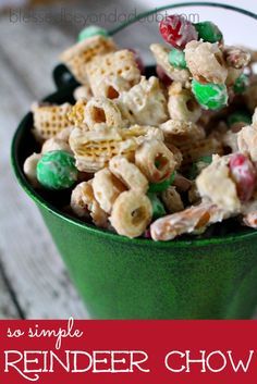 a green bucket filled with cereal and candy mix on top of a wooden table next to a