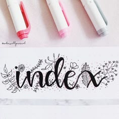 three markers with the word indexx written in black and white ink on top of a sheet of paper