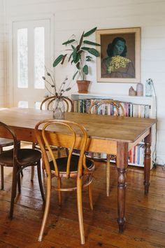 a dining room table with chairs and a potted plant