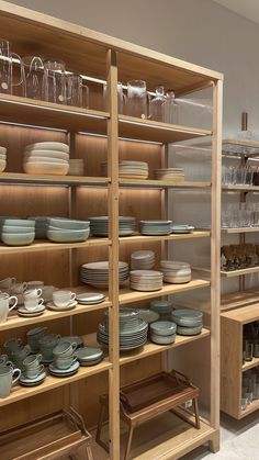 the shelves are full of dishes and cups for sale at the store or showroom