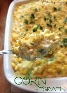 a spoon full of corn casserole on top of a white dish with green garnish