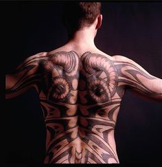 the back of a man with tattoos on his body