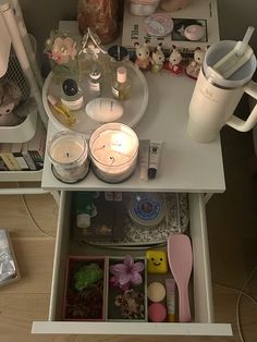 an organized table with candles, tea lights and other items on it in a small room