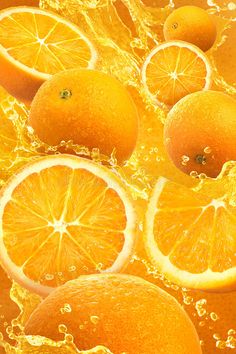 oranges and lemon slices are being mixed in with water to create an abstract background