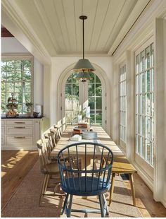 a dining room table and chairs in front of windows