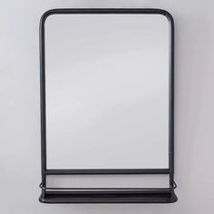 a black metal frame mirror hanging on a wall