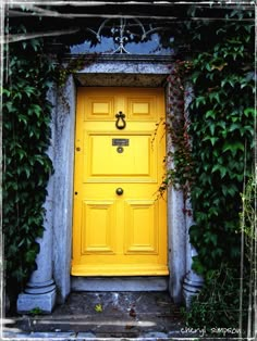 a yellow door is surrounded by ivy