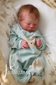 a baby wrapped in a blue blanket laying on top of a bed