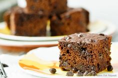 a piece of chocolate cake sitting on top of a white plate next to a fork