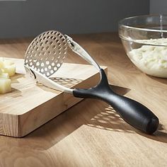 a cheese grater is sitting on a cutting board next to some diced potatoes