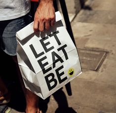 a person holding a bag that says let eat be