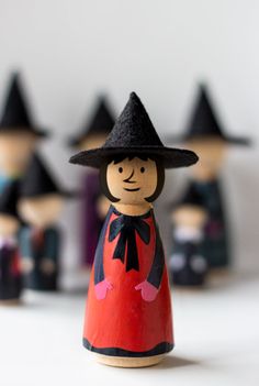 a wooden doll with a black hat and red dress