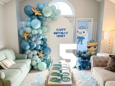 a living room filled with furniture and balloons in the shape of starfish on top of it