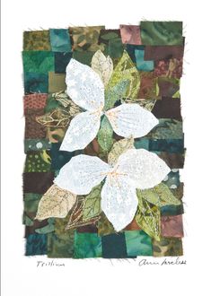 a white flower with green leaves on it's side in a patchwork quilt