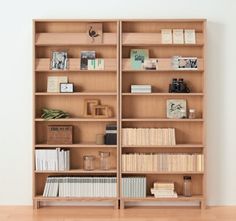 an empty bookcase with many books on it in a room next to a wall