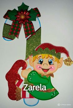 a christmas ornament with an elf holding a candy cane and the word zarella on it