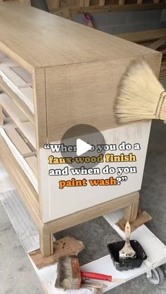 a person is painting a wooden cabinet with paintbrushes