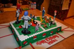 a birthday cake with figurines on top of it